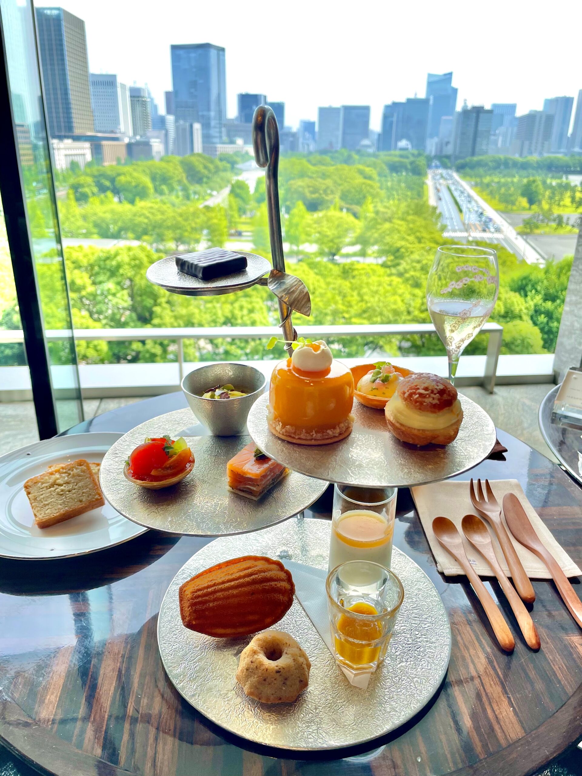 パレスホテル東京・プリヴェのアフタヌーンティーと皇居外苑を望む窓辺の景色。
Afternoon tea at Lounge Bar Privé, Palace Hotel Tokyo, overlooking the Imperial Palace Outer Gardens