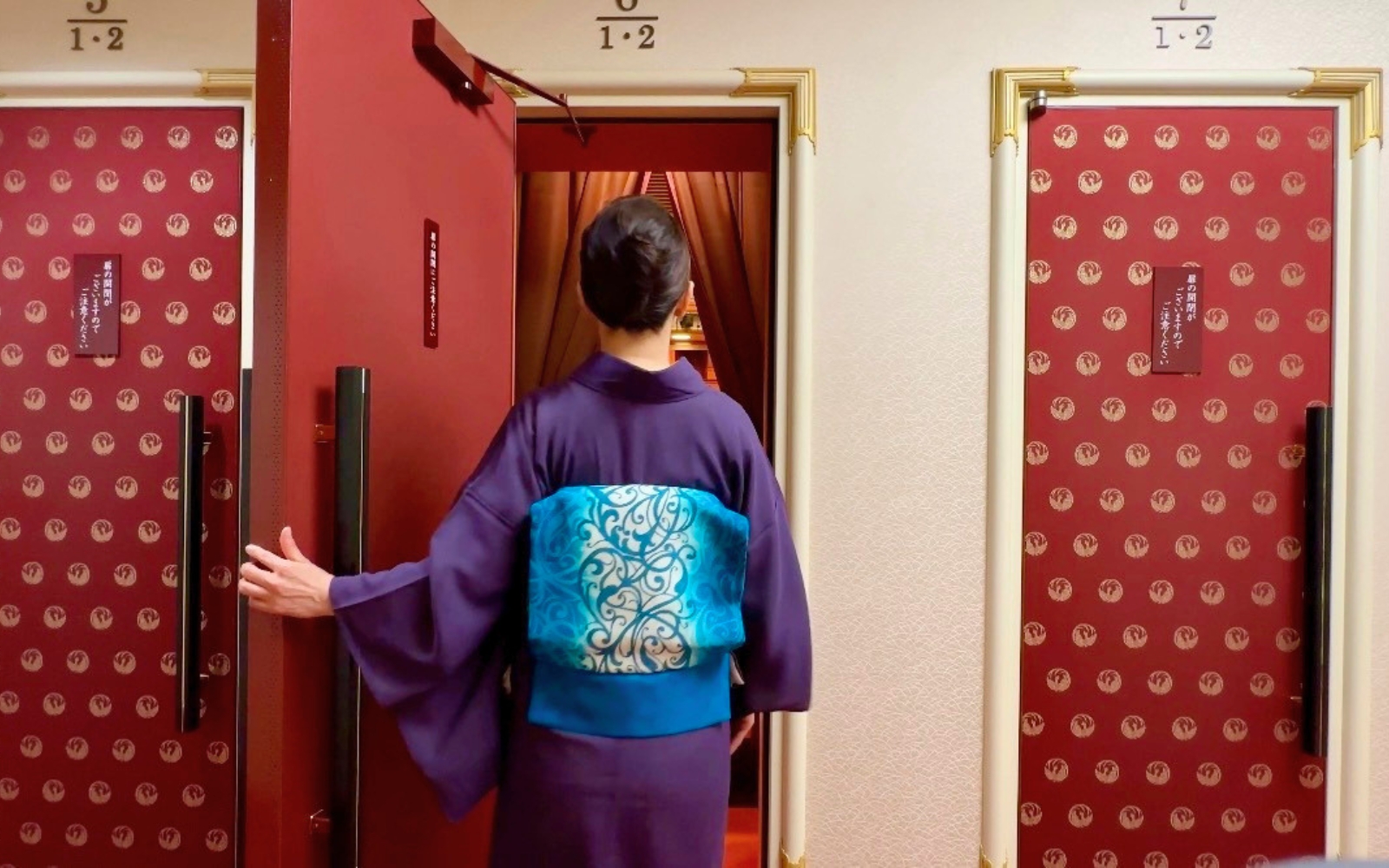 歌舞伎座の桟敷席の扉を開ける着物姿の女性